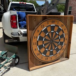 Very Large 48” Dartboard made of solid wood in a frame. Mounted on hinge so it swings out frame 52”  It of course, has holes in it from darts. We do n