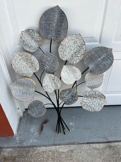 Metal leaf decoration; it is in good condition but could use a touch-up of paint. It is very attractive, measuring 37 inches high and 29 inches wide.
