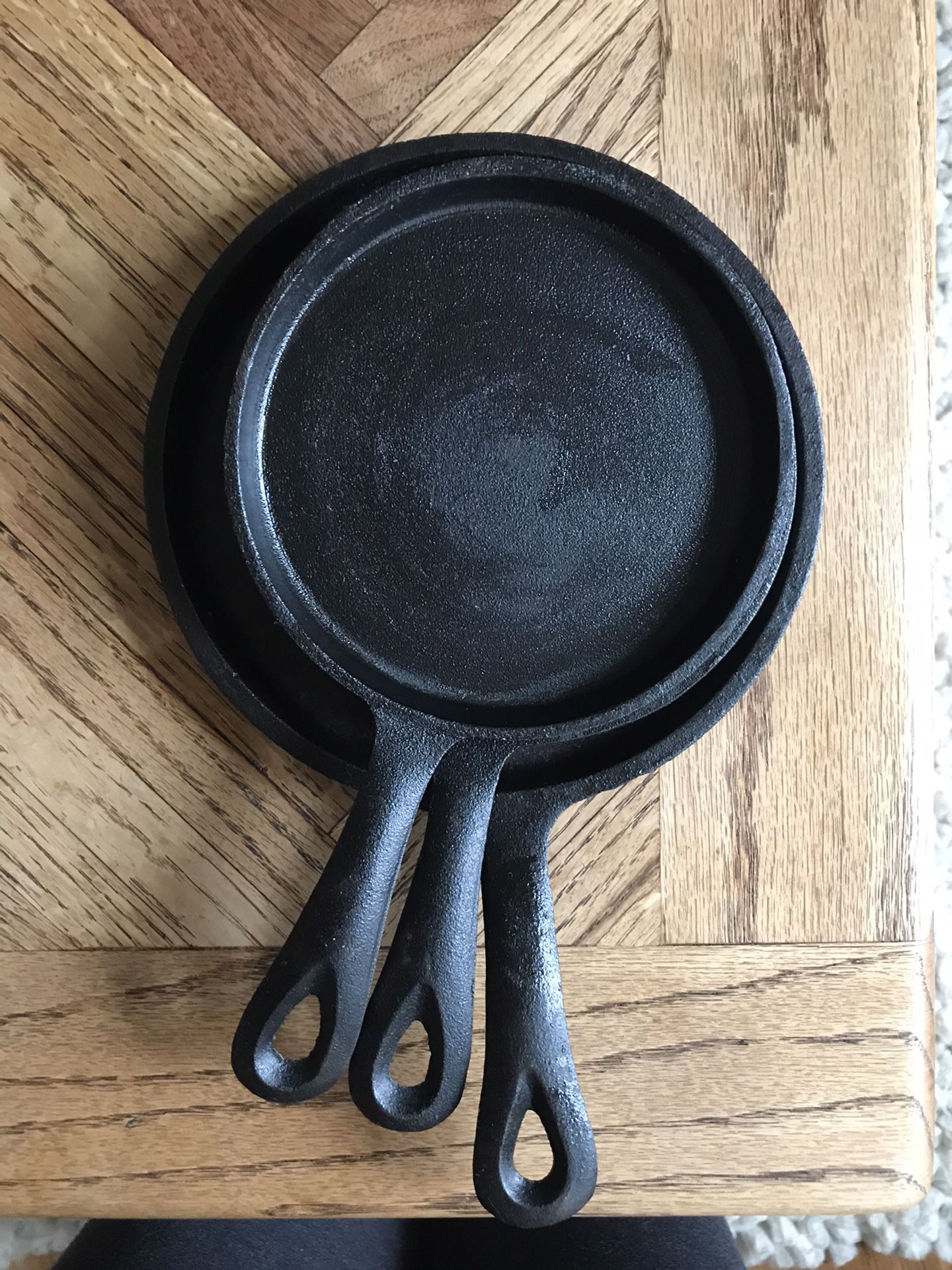Set of three small cast iron pans