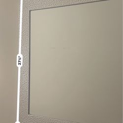 Modern decorative wall mirror with textured frame in excellent condition.