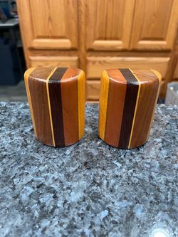 Wood Layered Design Pair of Salt And Pepper Shakers.  Very nice design.  Size approximately 3 inches tall.  Preowned never used only displayed.