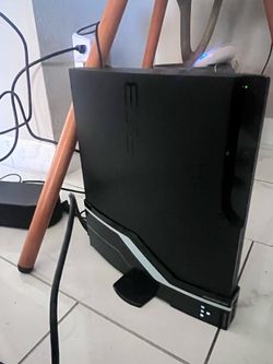 Black Sony PlayStation 3 Slim console with a vertical stand. This gaming system has a matte finish and includes a Call of Duty: Modern Warfare 3 game 