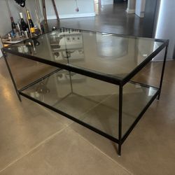 Glass coffee table with black metal frame