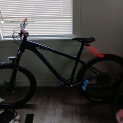 Kona mountain bike between 9-in tires on it big white ones 36 speed