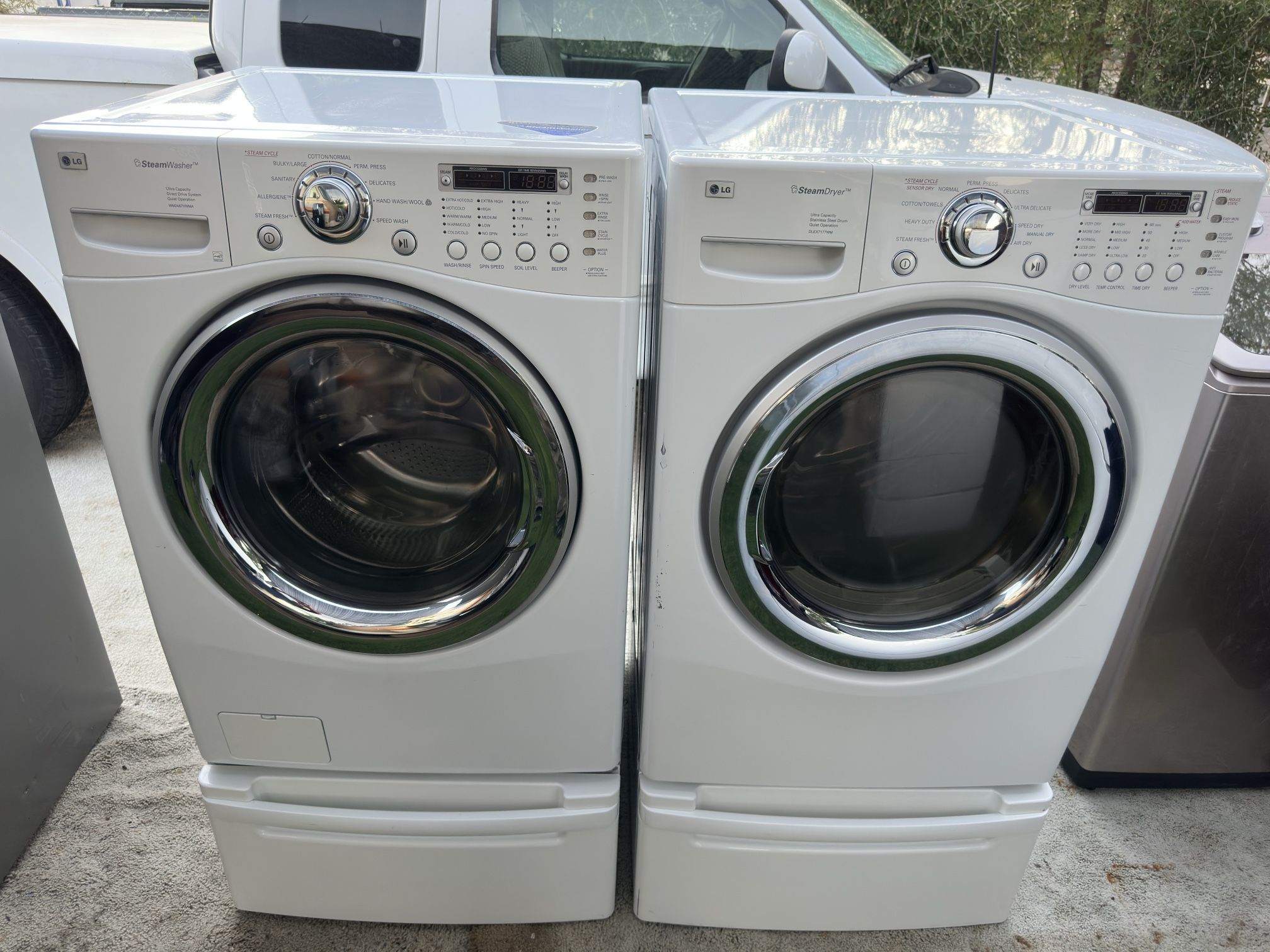 LG washer and electric dryer on pedestals