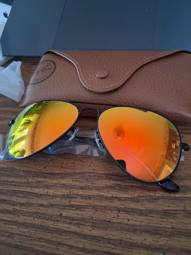 Ray Ban Aviators With A BLACK Frame And Red/Yellow Mirror Lenses.