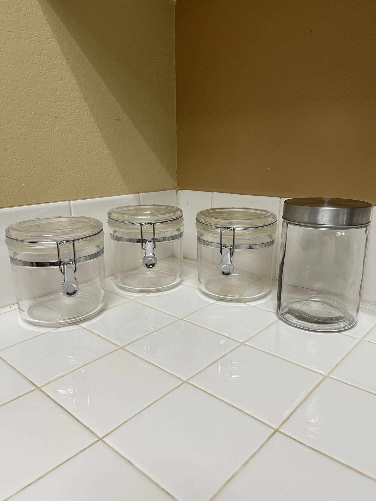 Clear Clamp 3 Canisters. Diameter 5”. H 5.5” And Glass Jar With Stainless Lid. $18 For All (4 Jars)