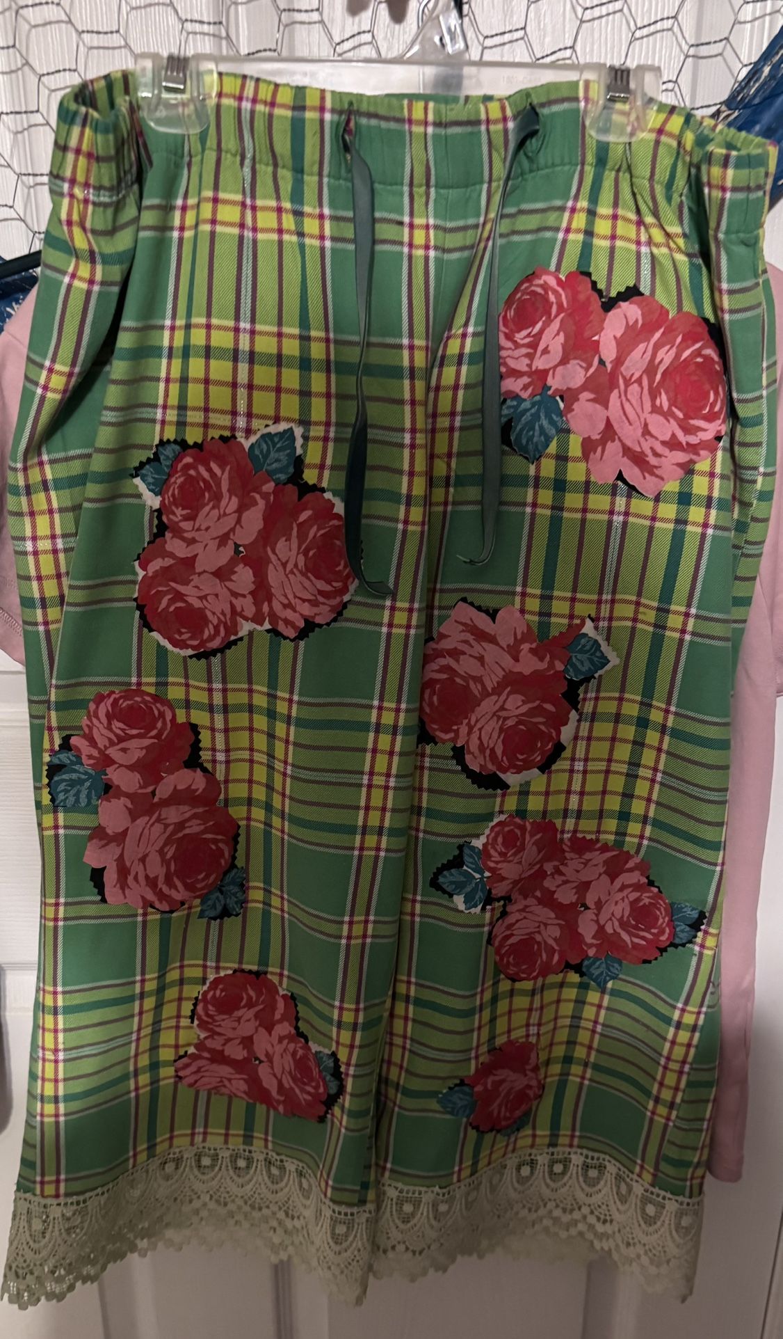 This stylish pants features a vibrant green plaid pattern adorned with bold floral designs. Perfect for adding a pop of color to your wardrobe.