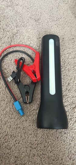 Handy car jump starter has a black portable unit with a built-in light. Includes red and black jumper cables with a blue connector. Also has a USB cha