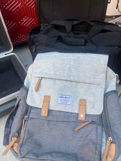 Stylish gray diaper bag backpack with multiple storage compartments.