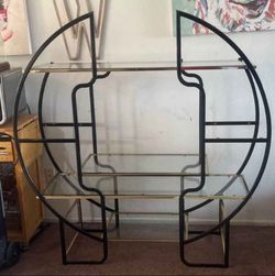 This item is a 1970s Hollywood Regency round room divider étagère