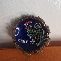 Chilean Souvenir Ashtray featuring a Painted Rooster over a blue speckled enamel background and framed by a metal link chain border.