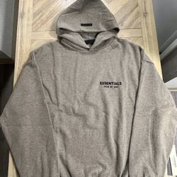 Fear of God Essentials hoodie, likely in the Dark Oatmeal colorway