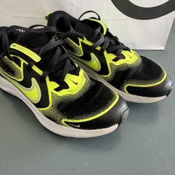 Youth Nike Downshifter 12 in a black and volt colorway.