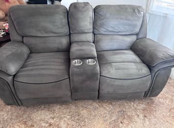 Couch recrinable con enchufes en medio y portavasos