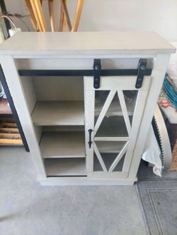 Accent cabinet with sliding glass barn door and shelving,  light gray