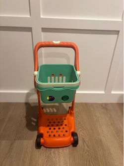 B. toys Shop & Glow Toy Cart in orange with a mint green basket
