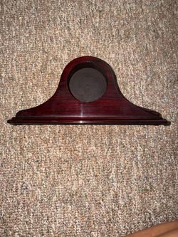 empty, polished wooden mantel clock case with a traditional arched or "Napoleon hat" profile