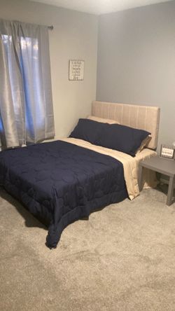 Full-size bed with boxspring, headboard, and nightstand