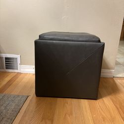 Brown faux leather storage ottoman with a reversible dark wood tray top. 