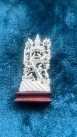 Antique Chinese carved ivory pagoda with figures on a wooden base.