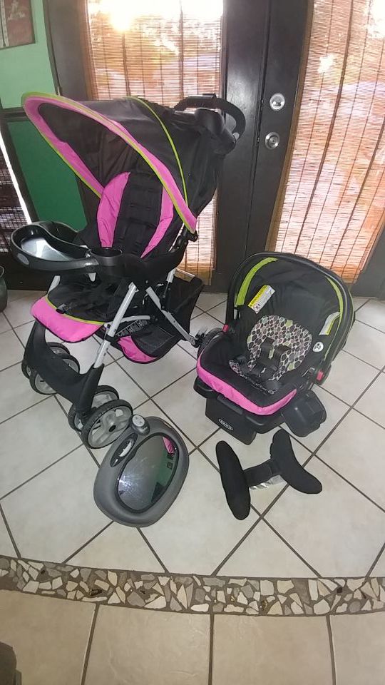 Graco baby stroller with car seat, additional head support and back seat mirror.