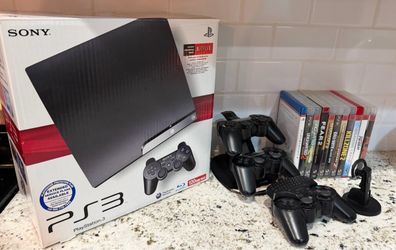 PlayStation PS3 slim with three controllers, keyboard, Bluetooth ear piece and 10 games