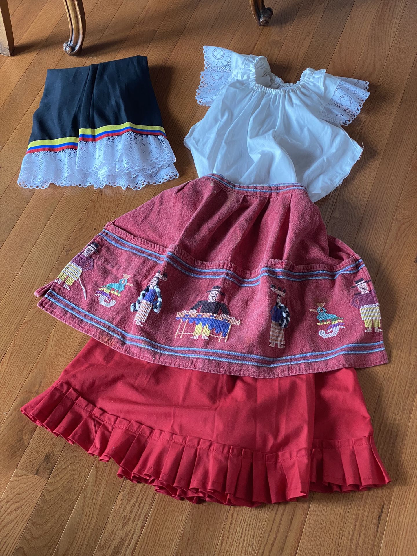 TWO LATINA OUTFITS ONE XS AND OTHER S - OUTFITS THE SAME BUT ONE HAS HAND EMBROIDERED APRON AND OTHER HAS LIGHT WOOL PONCHO BLACK WIT THIN WHITE TRIM