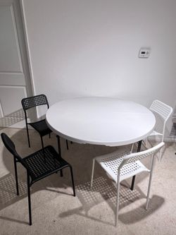 White round dining table with 4 chairs (2 black, 2 white)