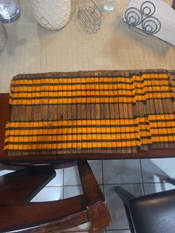 vintage woven bamboo slat placemats featuring a distinctive orange and dark brown/black striped pattern.