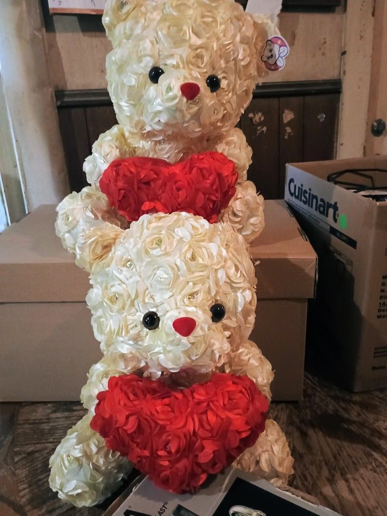 Two Identical Rose Teddy Bears With Floral Arrangements Holding A Heart