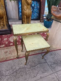 Vintage nesting tables with green onyx tops and ornate brass legs in the Hollywood Regency style.
