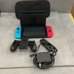 Nintendo switch unit with doc controllers, power cord, and soft case