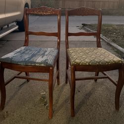 Two wooden chairs with carved backrests and patterned cushions seat 32"x16" each chair
