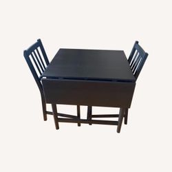 Simple wooden folding table and two chairs.