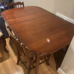Large mahogany dining table with 8 wood and wicker dining chairs and removable leaves