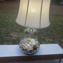 Big beautiful working sea shell filled glass lamp and shade. The lamp has a opening on the side to allow filling. The shade is removed and can be chan