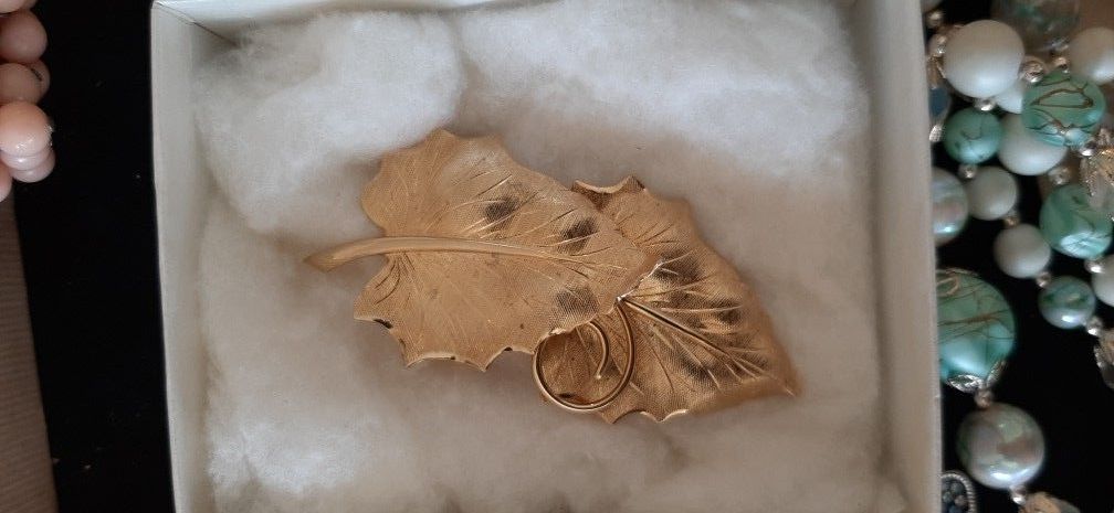 Elegant gold tone double leaf design brooch.
