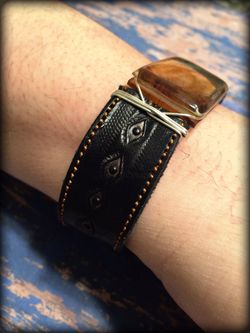 ** Men’s black leather bracelet with amber stone.