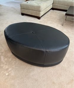 Black leather ottoman on wheels