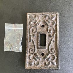 Cast iron wall switch plate, includes screws. Approximately 2.75 x 4.5”. Weight of 11 ounces