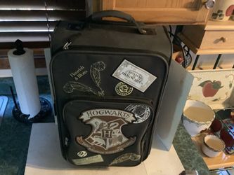 Harry Potter Hogwarts rolling suitcase is a carry-on size, typically measuring around 19 inches.The bag features prominent graphic patches, including 