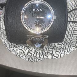 Women’s black and silver watch versus Versace