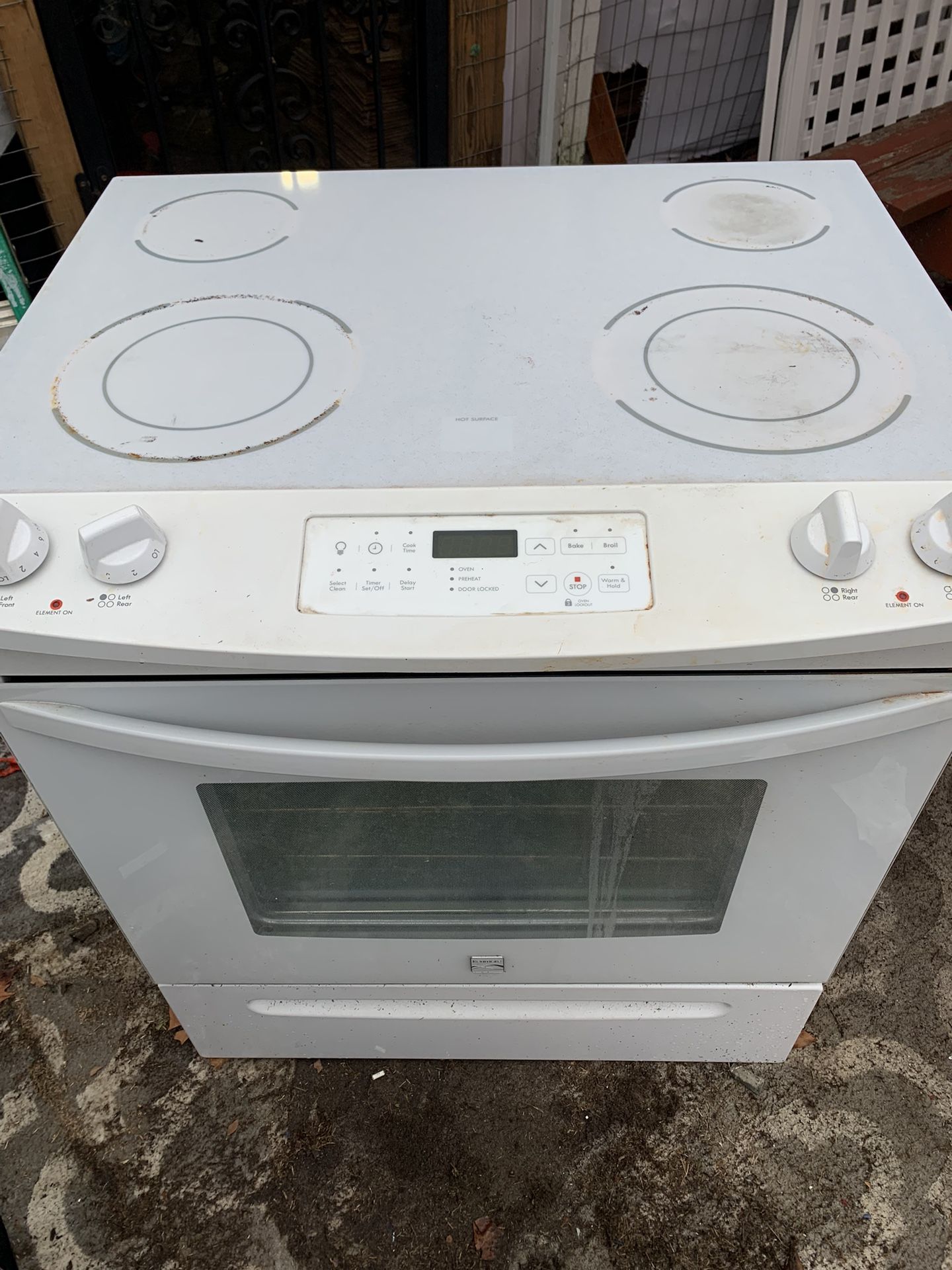 White glass top electric stove with controls in the front