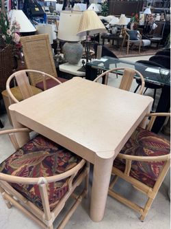vintage postmodern dining or game table set featuring bamboo-style rattan chairs and a light-colored, square tabletop.