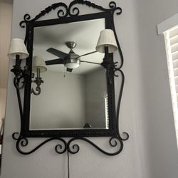 Vintage wrought iron wall mirror with dual candle-style sconces and pleated shades