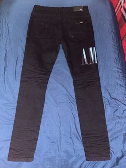 Size 34 Amiri Tie-Dye Core Logo Jeans in black featuring distressed knee rips and blue tie-dye underlays