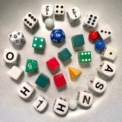 Bundle of different kinds of dice and game pieces marbles