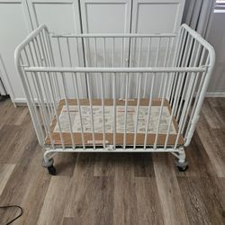 White Metal Mini Crib With Wheels