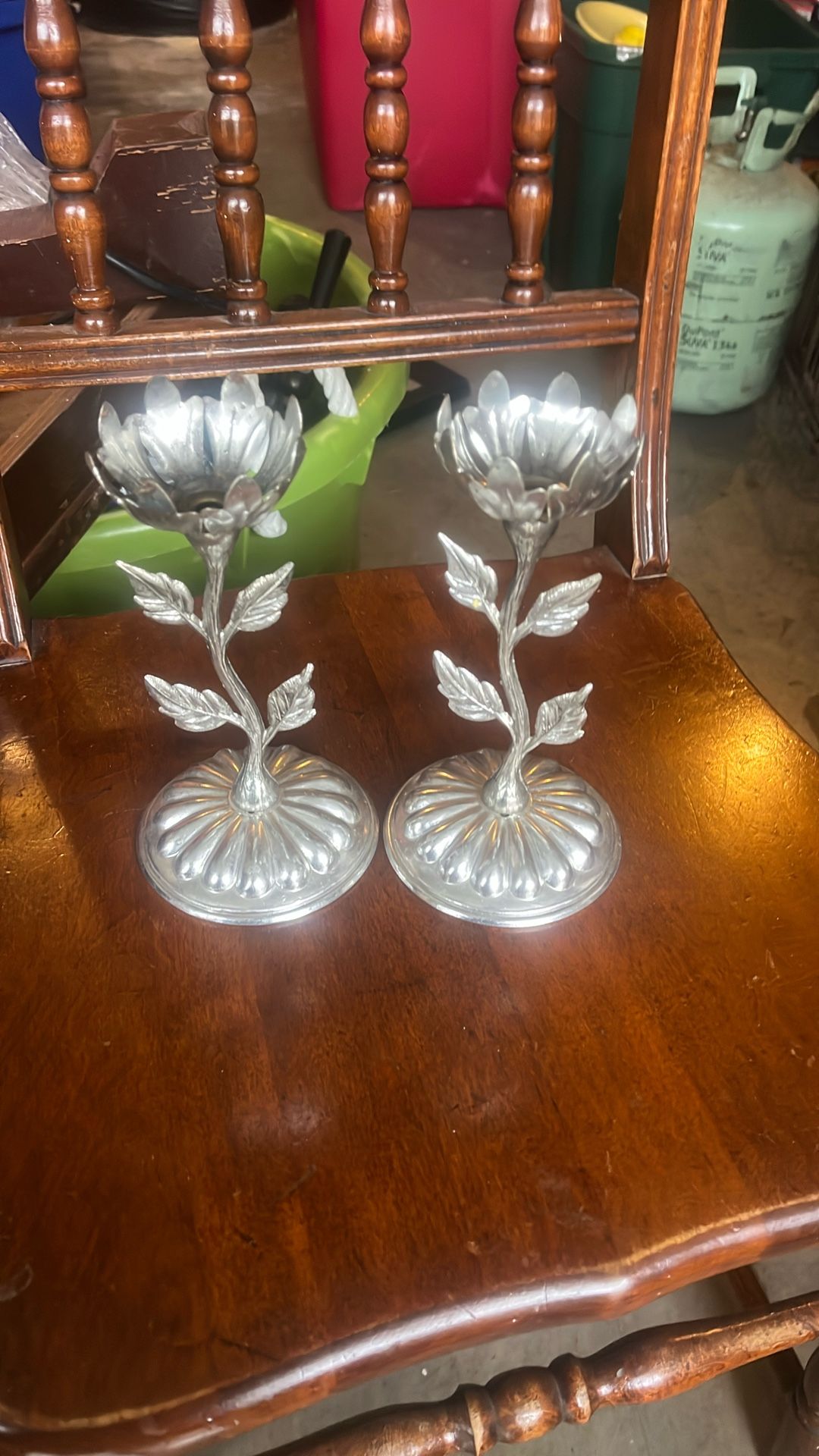 This is a floral-themed metal candlestick holder, also known as a candelabrum. It is designed to hold a single candle and is shaped like a flower with
